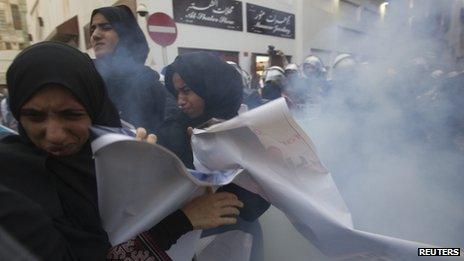 Women protesters run after a stun grenade is fired at them in Old Manama (18 April 201")