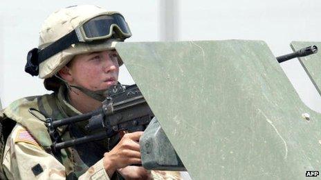 A female US soldier manning a machine gun on a vehicle during clashes in the northern Iraqi city of Mosul 13 June 2003