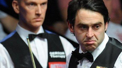 Ronnie O'Sullivan contemplates a shot as Peter Ebdon looks on