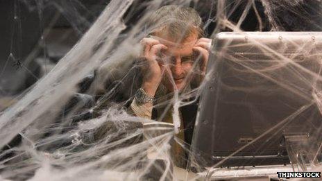 Man at desk covered in cobwebs