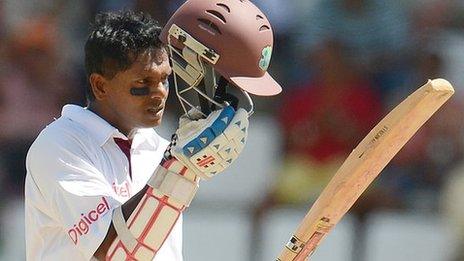 Shivnarine Chanderpaul lifts his helmet after reaching 10,000 Test runs