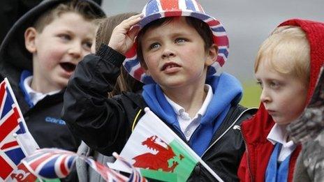 A school boy watches Britain"s Queen Elizabeth arrive by helicopter in Aberfan