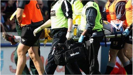 Tom Croft being stretchered off against Harlequins