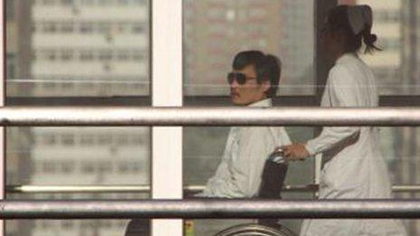 Chinese activist Chen Guangcheng (L) is seen in a wheelchair pushed by a nurse at the Chaoyang hospital in Beijing.