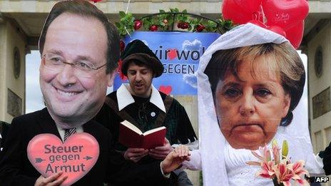 Activists wearing masks of Francois Hollande and Angela Merkel taking part in a fake marriage in Berlin, 7 May 2012