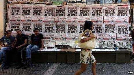 Woman walking past Syriza posters