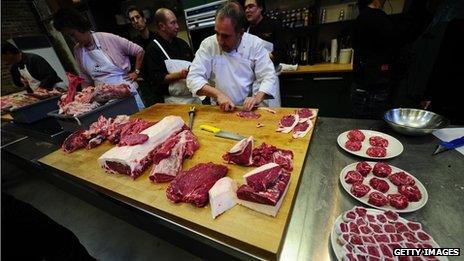 Le Bourdonnec cutting up meat on a table