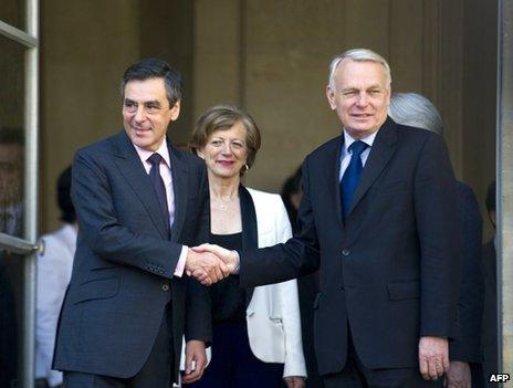 French Prime Minister Jean-Marc Ayrault (right) shakes hands with his predecessor, Francois Fillon, at the Matignon Palace in Paris, 16 May