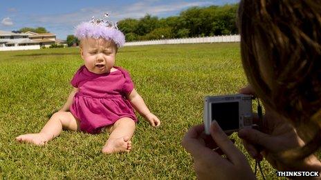 Woman takes a photography of a young child