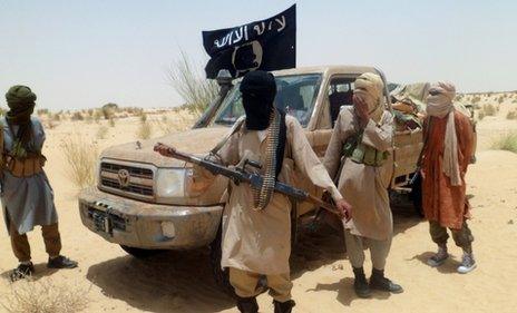 Ansar Dine men stand next to a car