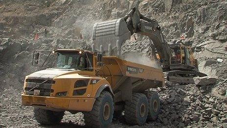 Digger and truck moving rocks