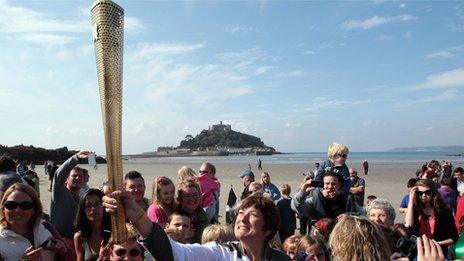 Sarah Blight holds the torch aloft near St Michael's Mount