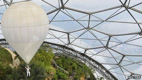 Ben Fogle rises high inside a biome at the Eden Project with the Olympic flame in a lantern