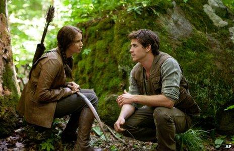 Jennifer Lawrence as Katniss Everdeen and Liam Hemsworth as Gale Hawthorne