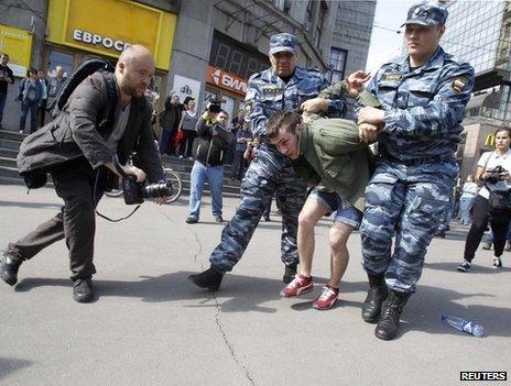 Russian police detain a protester at an unapproved rally in Moscow, 7 May