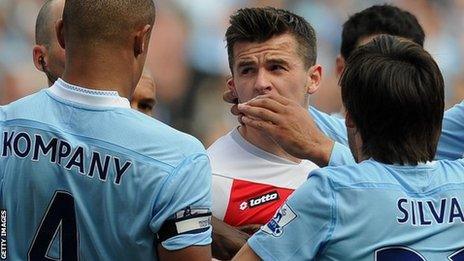 QPR midfielder Joey Barton confronts the Manchester City players