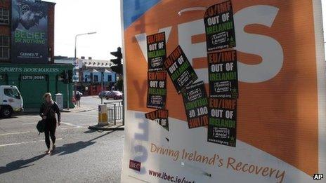 A poster supporting the EU fiscal treaty is defaced by anti-EU stickers at a crossroads in Dublin