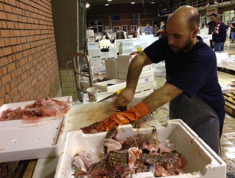 A man cleans fish in a market in Kavala, northern Greece