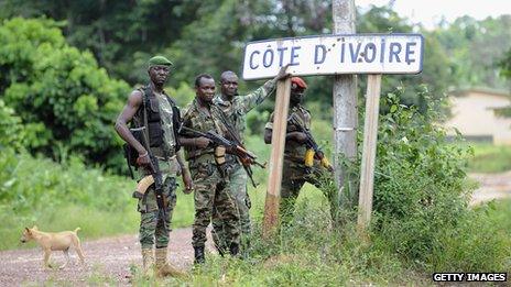 A photograph from April 2011 showing Ivorian militiamen standing on the border between Ivory Coast and Liberia