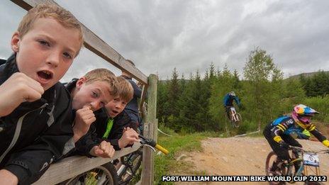 Boys cheering on mountain bike riders