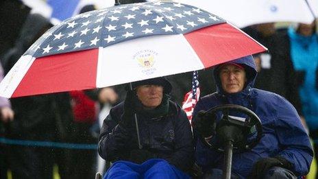 US skipper Pat Cornett (left) shelters under an umbrella as she nurses a broken ankle