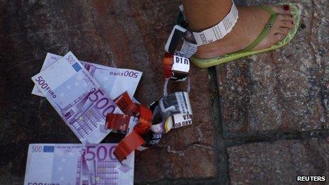 A demonstrator hangs fake Euro notes on her leg during a protest against Spain's bailout in Malaga June 10 2012.