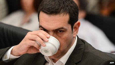 Alexis Tsipras takes a drink during a news conference in Athens, 12 June