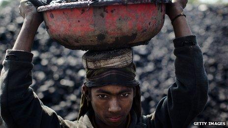 Young boy carrying coal at a mine in India