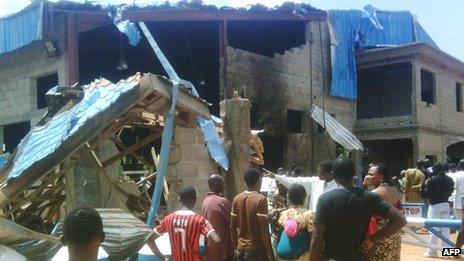 Bystanders look at the Sharon Church after it was struck by a suicide bomber's attack in Kaduna on 17 June 2012.