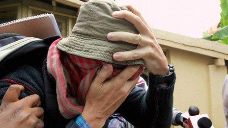 Pascal Mazurier with face covered and hat on when arrested