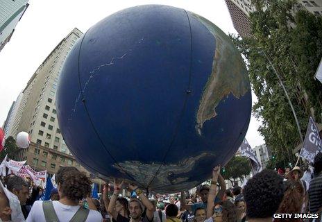 Demonstrators hold up an inflatable globe during a march at the Rio summit