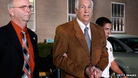 Former Penn State assistant football coach Jerry Sandusky (C) leaves the Centre County Courthouse in handcuffs after a jury found him guilty in his sex abuse trial on 22 June 2012 in Bellefonte, Pennsylvania, US