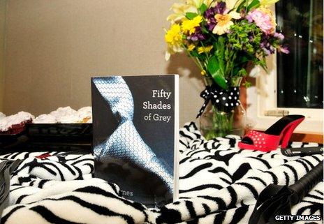 Fifty Shades of Grey by EL James, with high heel and whip on zebra skin rug