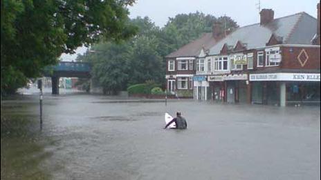 Man on surfboard in flooded Hull street