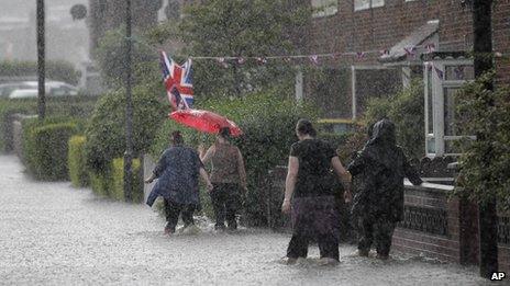 People wade through flood water