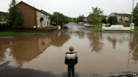 Boy looks at flooded junction