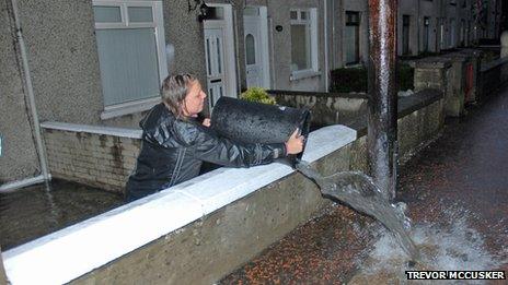 Woman pours out bucket of water