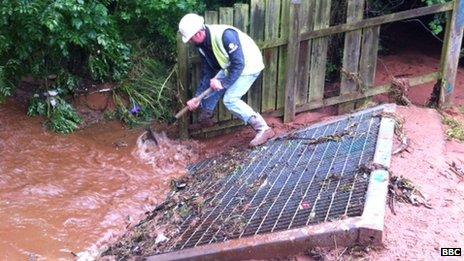 Worker clears mud from drain