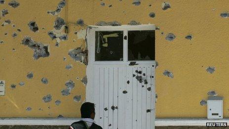 Resident looks at the bullet-riddled town hall in of San Cristobal de las Barrancas