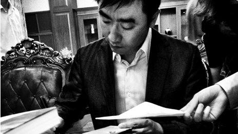 Rui Chenggang signs copies of his book