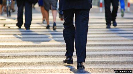 Business people walking across pedestrian crossing