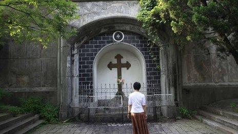 A woman prays outside the Sheshan Catholic Church in Shanghai