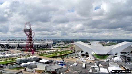 The ArcelorMittal Orbit sculpture standing in front of the Olympic Stadium, with the Aquatics Centre to the right