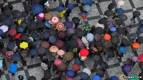 Aerial photo of crowd of people holding umbrellas