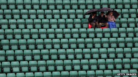 Spectators under umbrellas