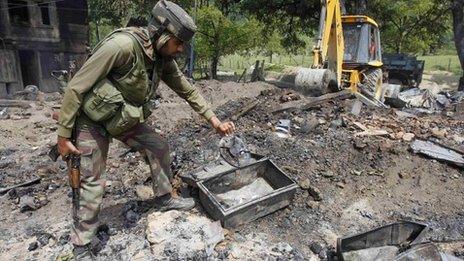 An Indian soldier searches for the bodies of suspected militants in the rubble of a house after a gun battle in Baban, 90km (55 miles) north of Srinagar