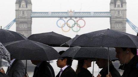 Commuters walk across London Bridge