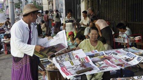 A man buys a weekly news journal at a roadside newspaper stand in Rangoon, Burma, 10 June, 2012