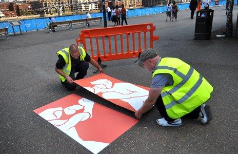 Workmen fix an Olympic pictogram in the Borough of Southwark