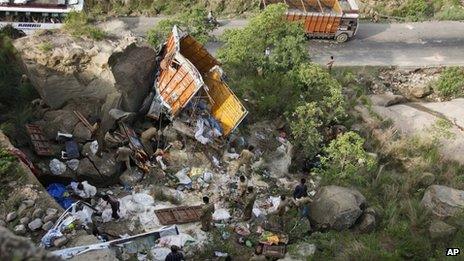 Police officers inspect the wreckage at an accident site about 65 kilometers from Jammu, India, Friday, July 27, 2012.